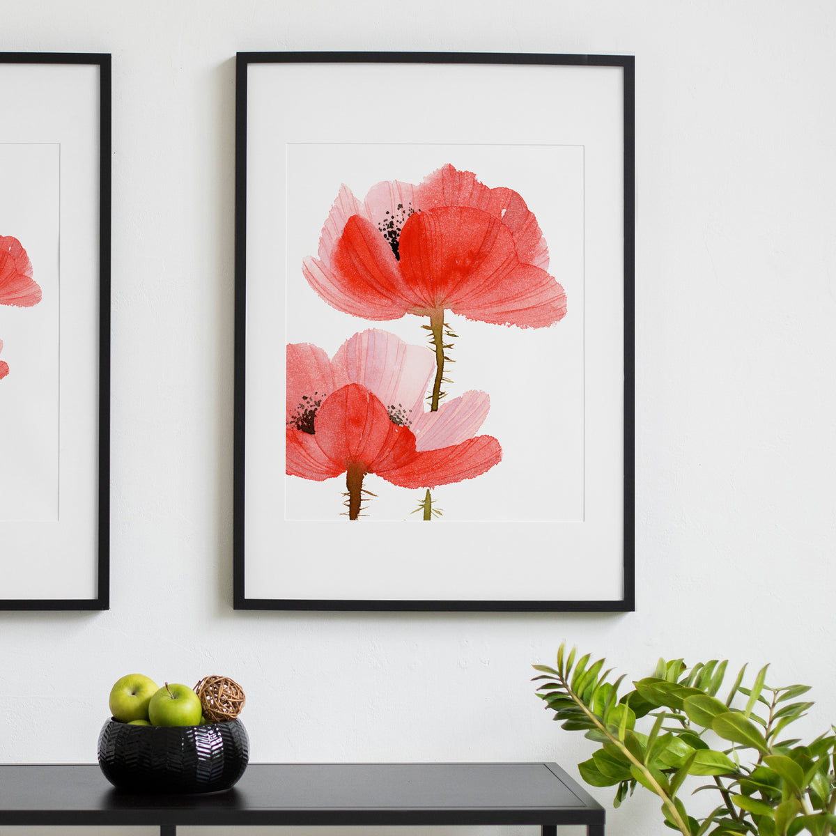 Gerahmter Fine-Art-Print mit roten Mohnblumen über einer schwarzen Konsole
